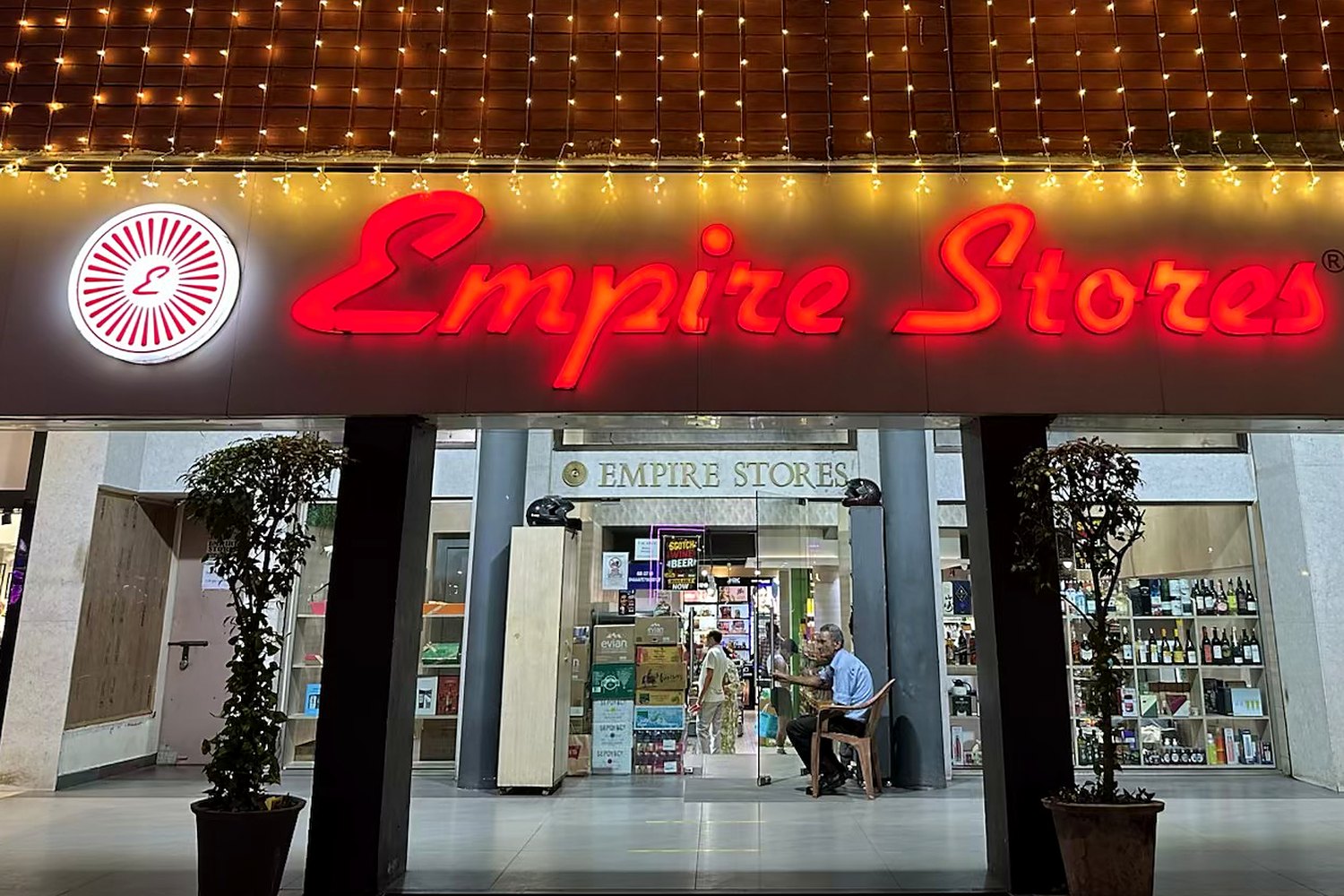 The Empire Stores storefront at night, its red neon sign lit beneath a façade of fairy lights